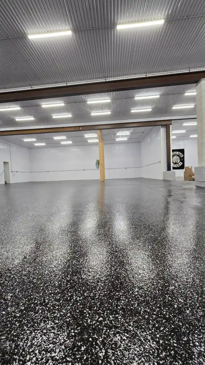 Black flake epoxy floor across a large commercial shop