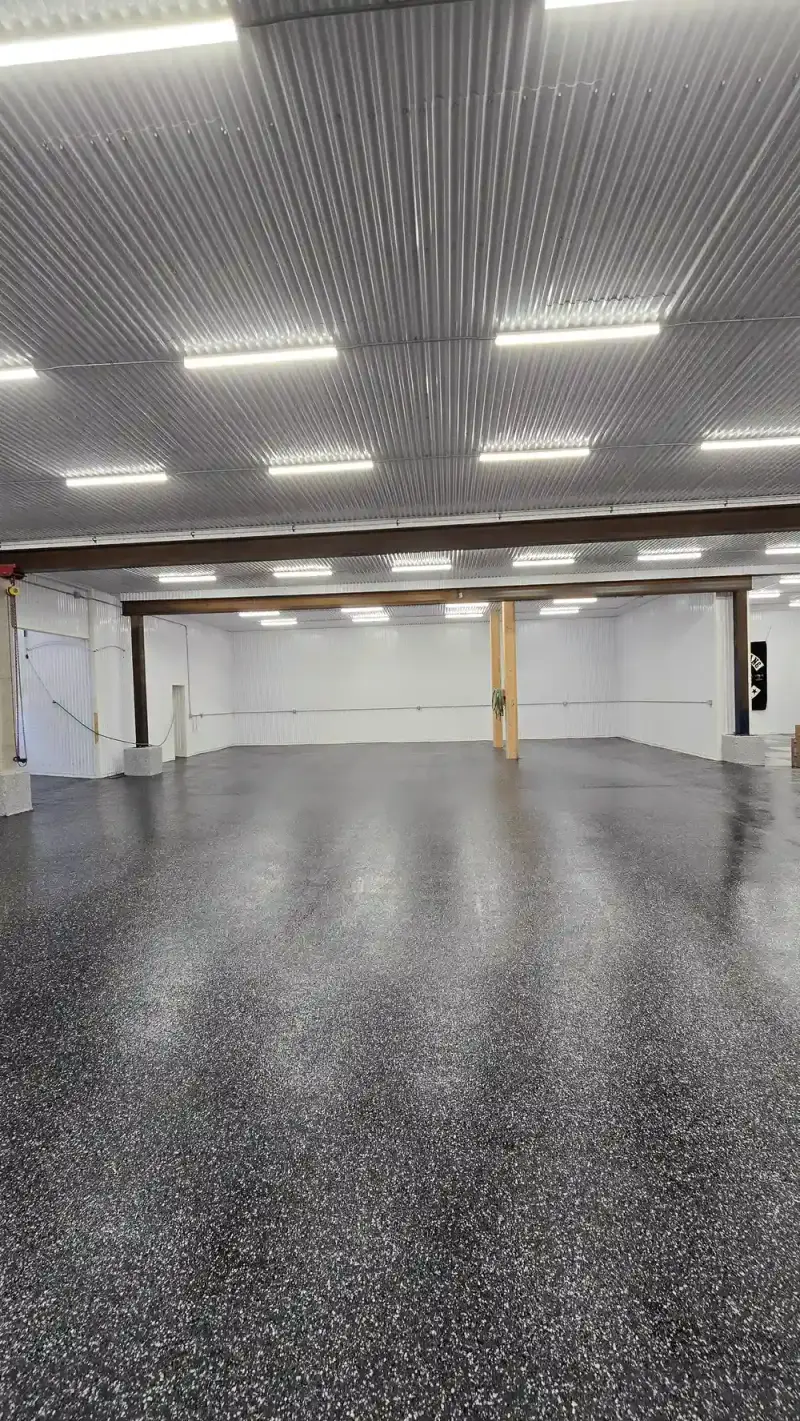 Black flake epoxy coating across an open warehouse floor