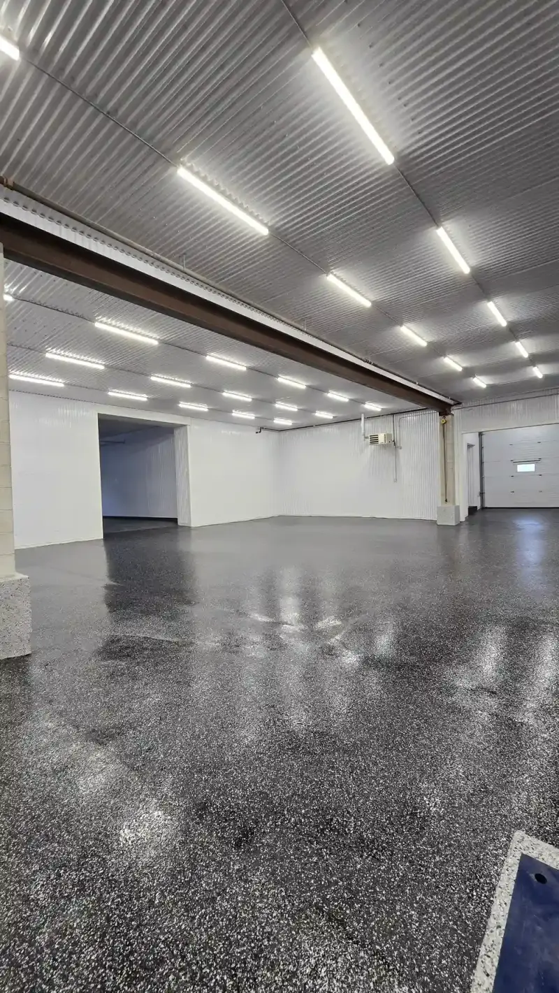 Glossy black flake epoxy floor in a commercial shop
