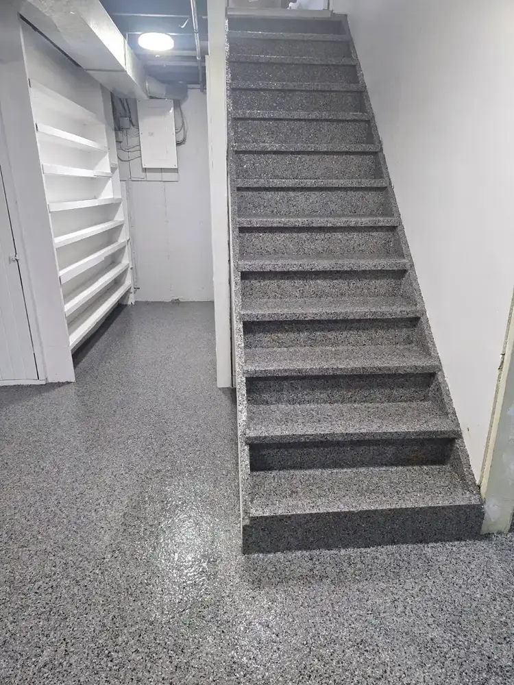 Grey flake epoxy coating around finished basement stairs