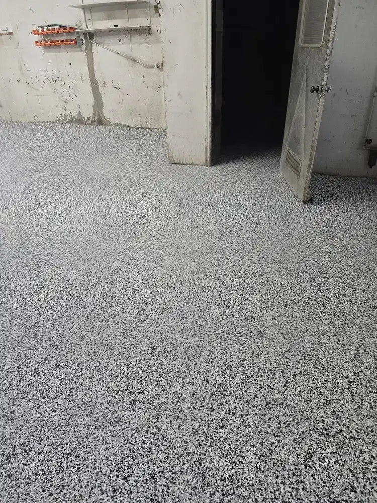 Grey flake epoxy floor leading to an interior doorway in a garage