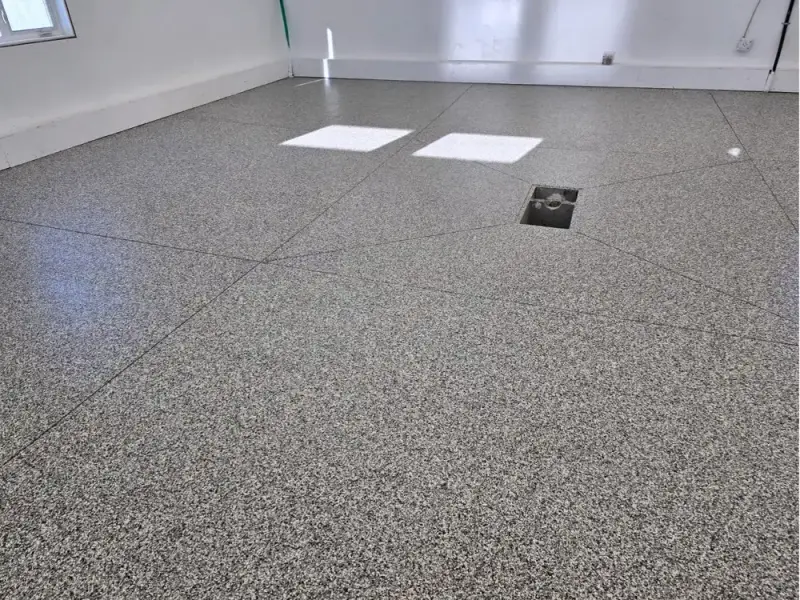 Grey flake epoxy floor extending through a residential garage