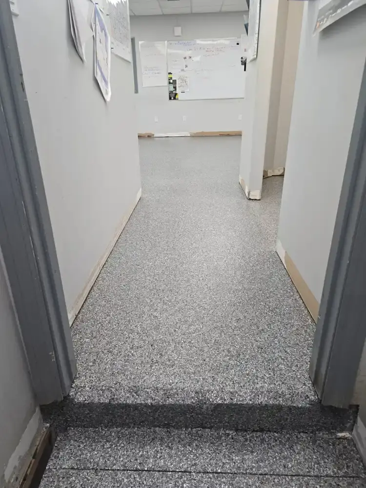 Grey flake epoxy floor running down an office hallway