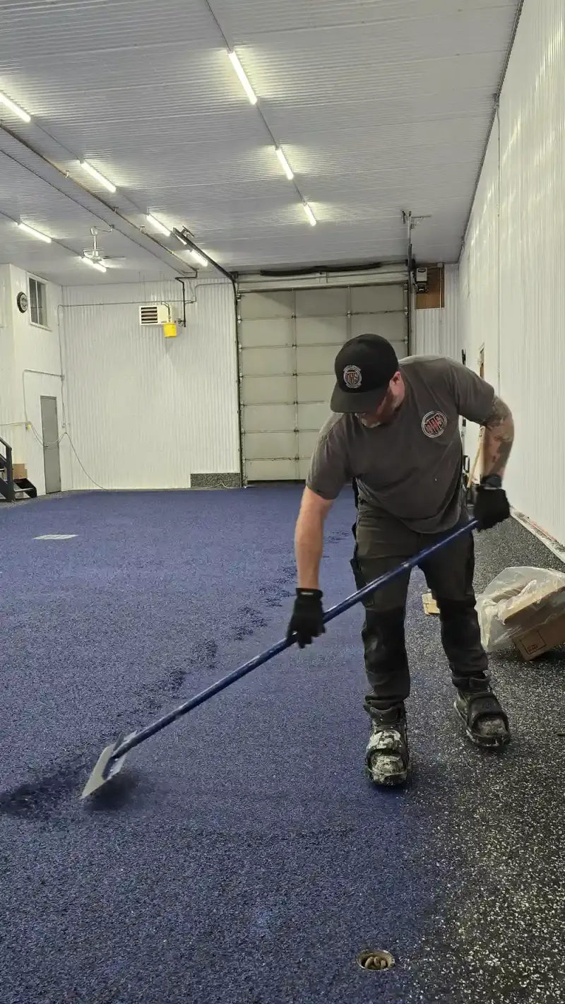 Mike Toupin scraping excess flakes from an epoxy floor