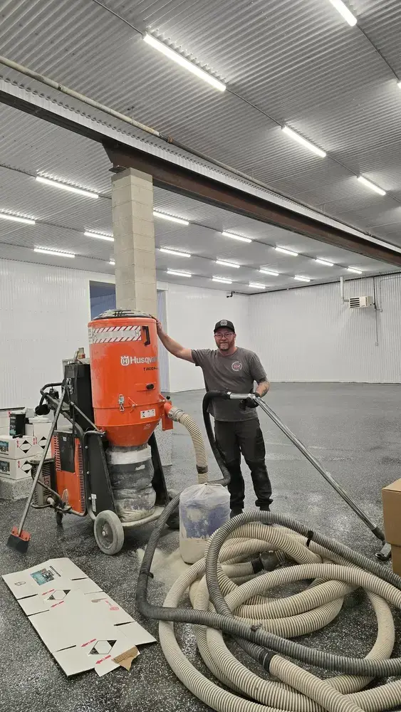 Mike Toupin standing beside a HEPA floor grinder