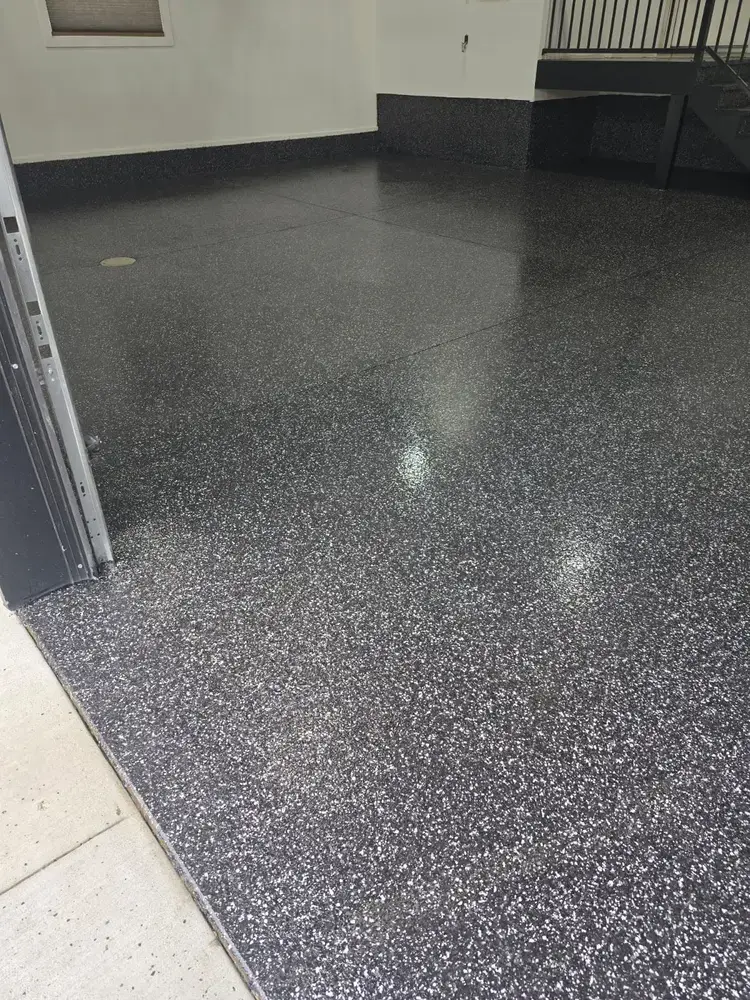 Raven flake epoxy floor across a clean garage entry