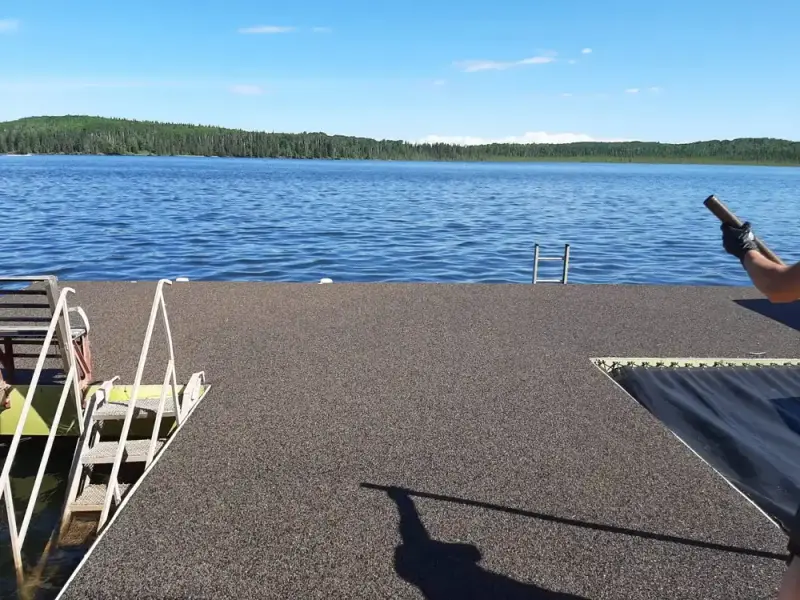 Rubber-surfaced pontoon dock on a lake with a ladder