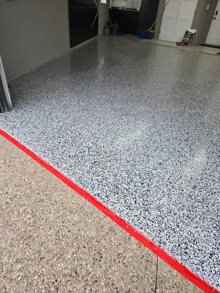 Black and white flake epoxy floor at a garage entry