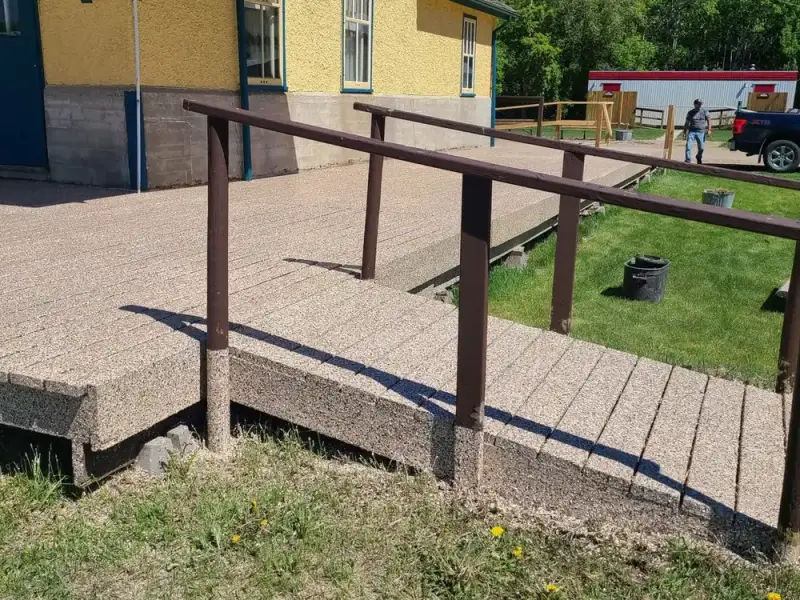 Tan speckled coating on an outdoor accessibility ramp and deck